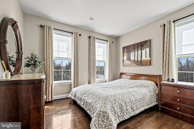 bedroom with baseboards and dark wood-style flooring