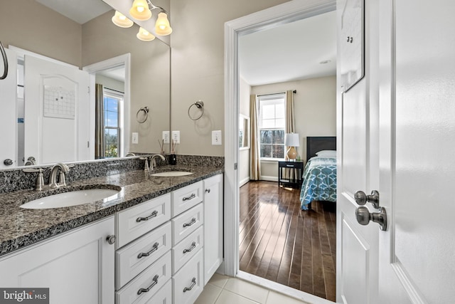 bathroom with double vanity, wood finished floors, and a sink