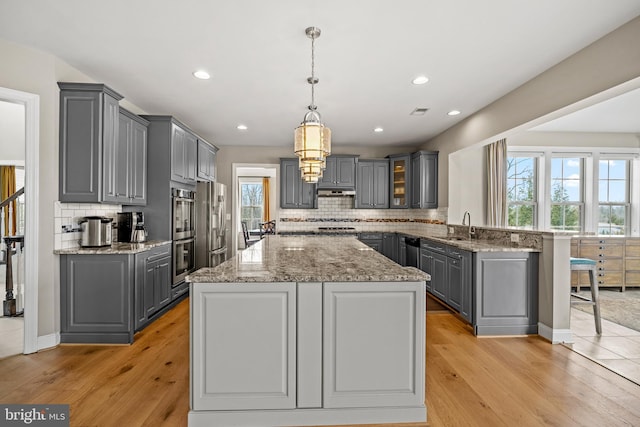 kitchen with a sink, gray cabinets, and stainless steel appliances