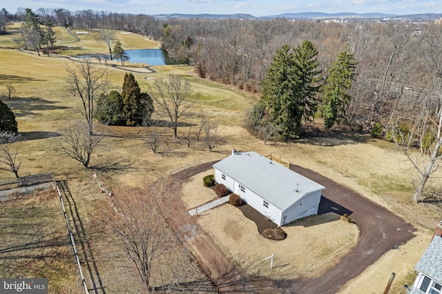 drone / aerial view featuring a wooded view and a water view