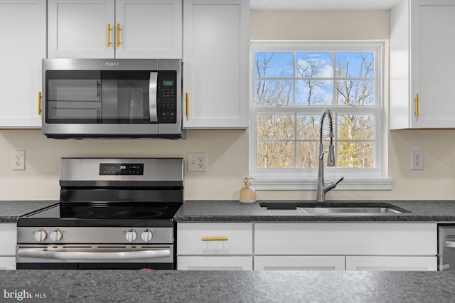 kitchen with white cabinets, appliances with stainless steel finishes, and a sink