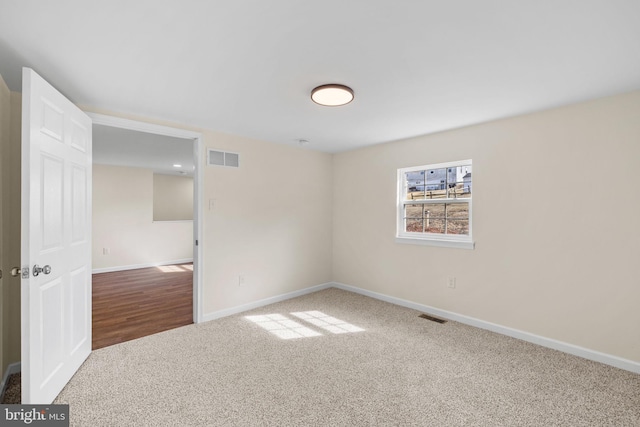 carpeted spare room with baseboards and visible vents