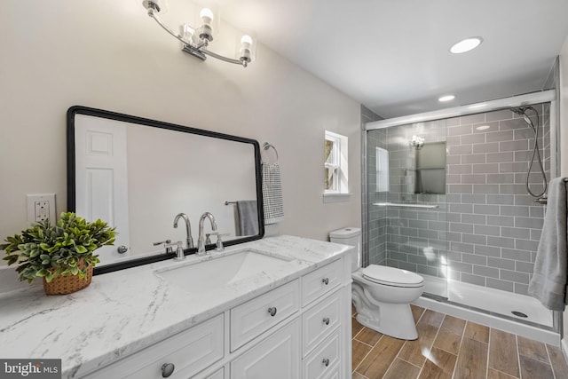 full bath featuring vanity, toilet, a shower stall, and wood tiled floor