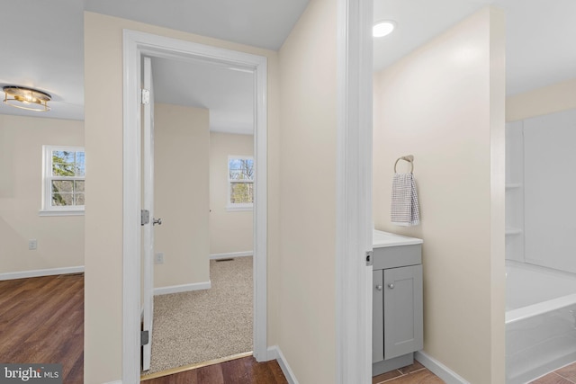 full bath with a wealth of natural light, baseboards, and vanity