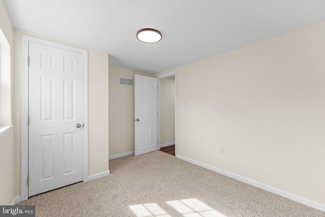 unfurnished bedroom featuring visible vents, baseboards, and carpet