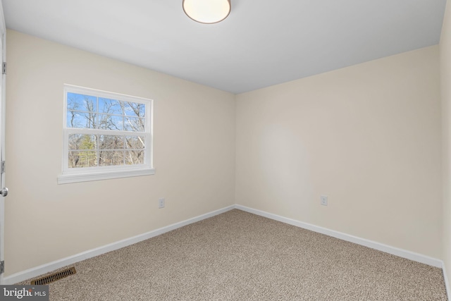 spare room featuring visible vents, baseboards, and carpet