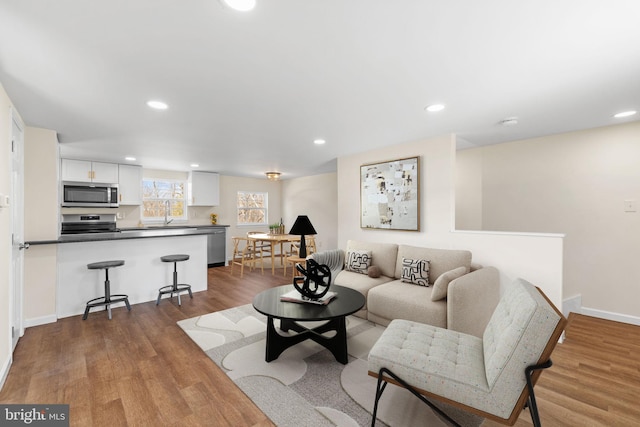 living area featuring recessed lighting, baseboards, and wood finished floors