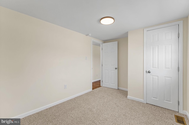 unfurnished bedroom featuring carpet, visible vents, and baseboards