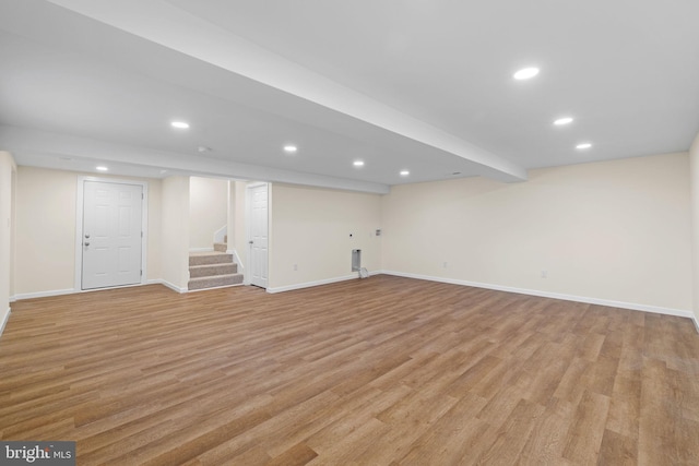 finished basement with light wood finished floors, stairway, recessed lighting, and baseboards