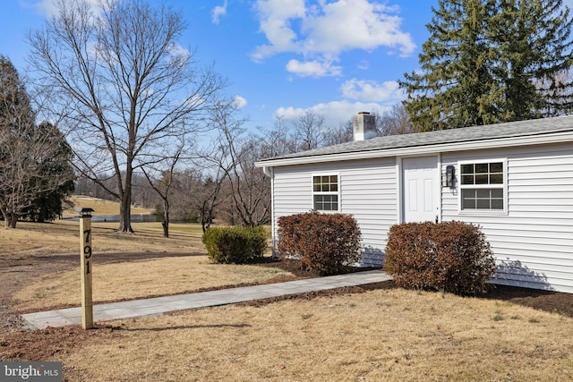 exterior space featuring a yard and a chimney