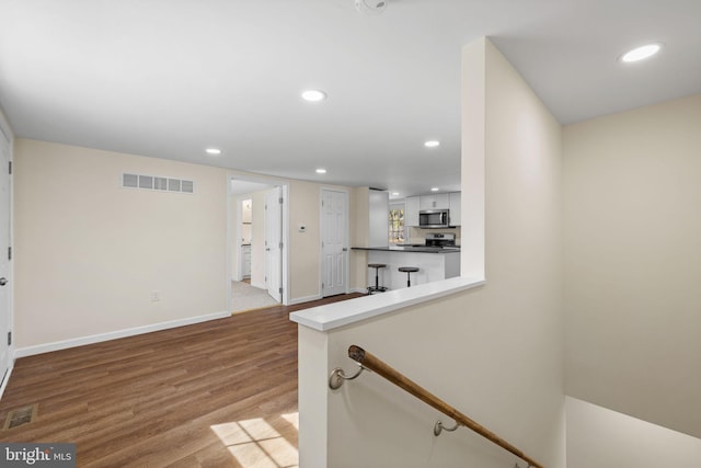 interior space with recessed lighting, wood finished floors, visible vents, and baseboards