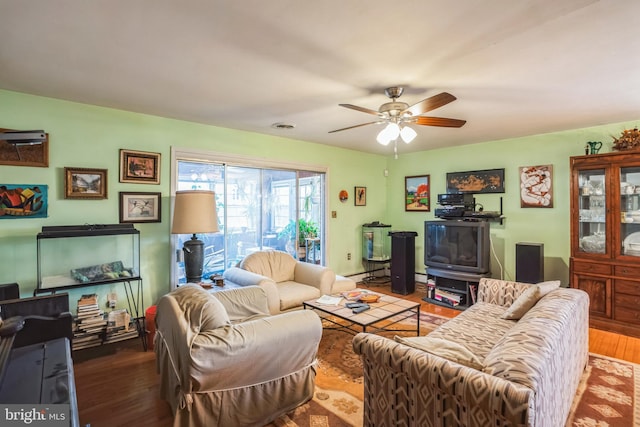 living room with a ceiling fan, wood finished floors, visible vents, and a baseboard radiator