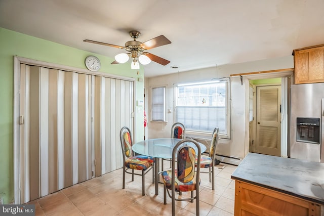 dining area featuring light tile patterned floors, a ceiling fan, and a baseboard radiator