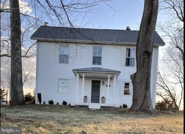 view of front facade featuring a chimney and a front yard