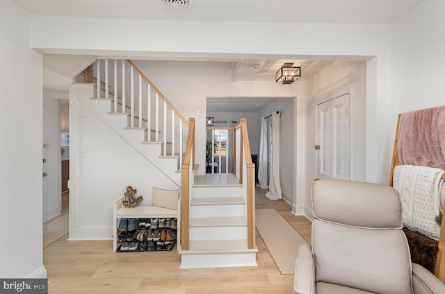 staircase with wood finished floors and baseboards