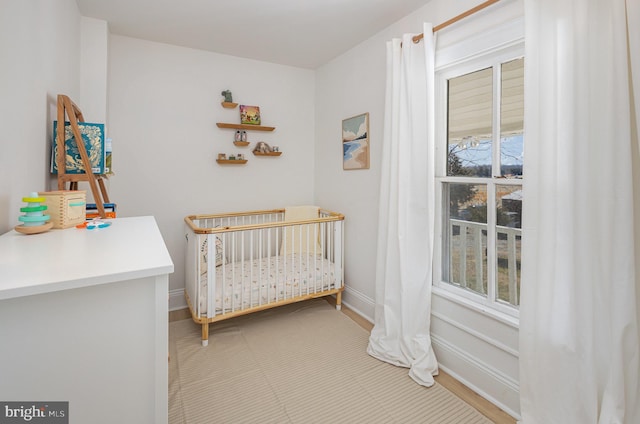 bedroom with a nursery area and baseboards