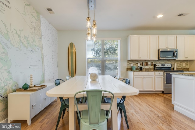 dining area featuring recessed lighting, visible vents, light wood-style flooring, and wallpapered walls