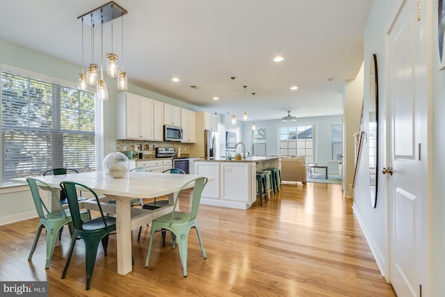 dining space featuring light wood-type flooring, plenty of natural light, baseboards, and recessed lighting