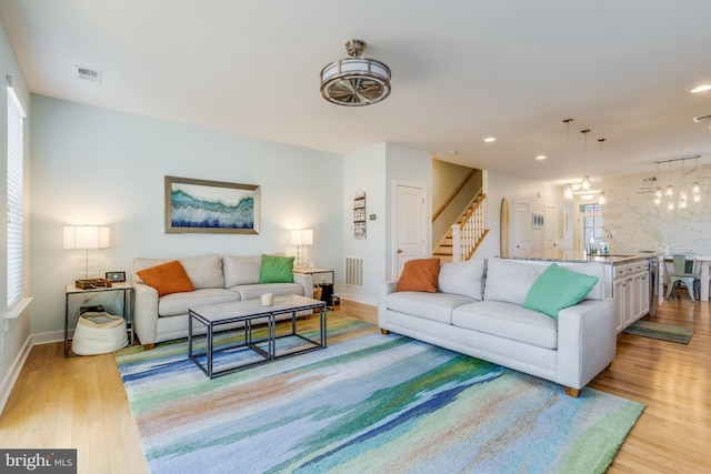 living area with light wood finished floors, stairway, visible vents, and recessed lighting