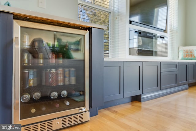 bar featuring wine cooler and light wood finished floors