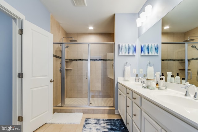 bathroom with visible vents, a sink, a shower stall, and tile patterned floors