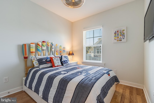 bedroom featuring wood finished floors and baseboards