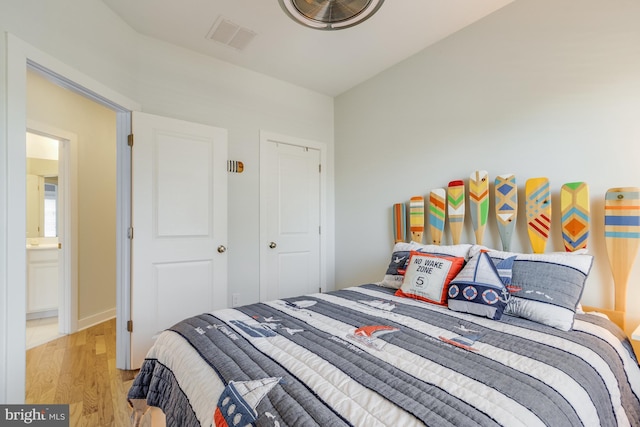 bedroom with light wood finished floors and visible vents