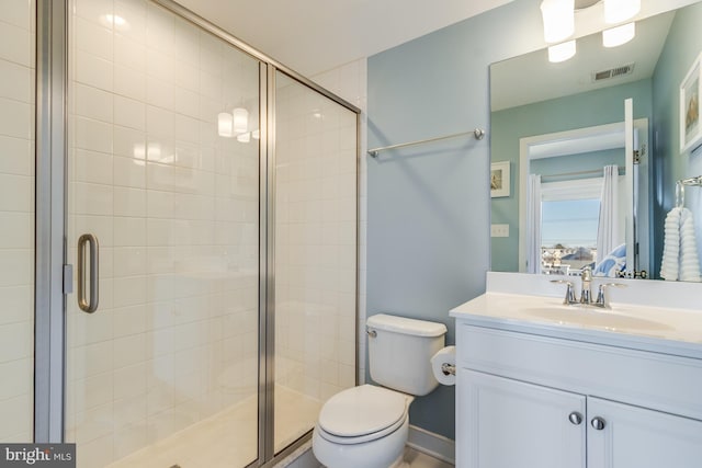 ensuite bathroom featuring visible vents, a stall shower, vanity, and toilet