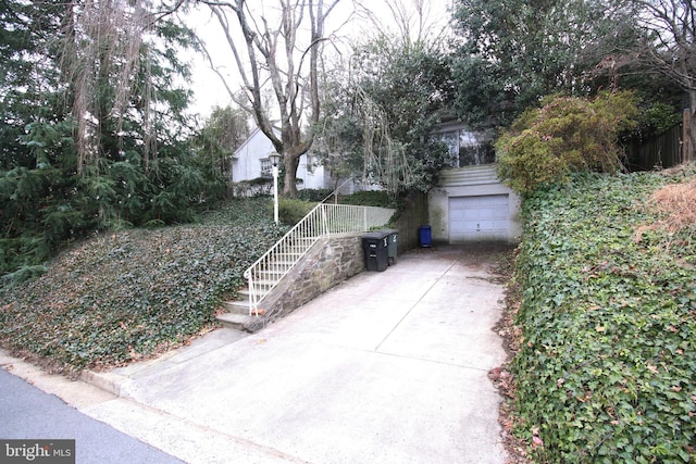 exterior space featuring driveway, an attached garage, and an outdoor structure