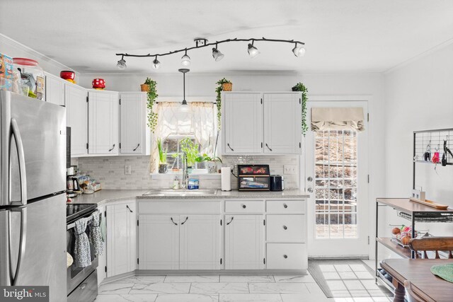 kitchen featuring a wealth of natural light, stainless steel appliances, light countertops, and a sink
