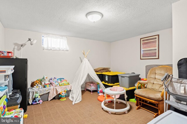 game room with a textured ceiling and carpet