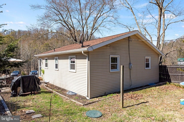 view of side of property featuring fence and a lawn
