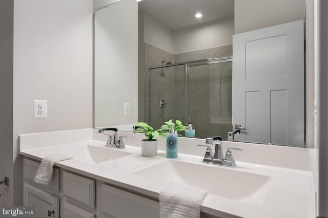 bathroom featuring a stall shower, a sink, and double vanity