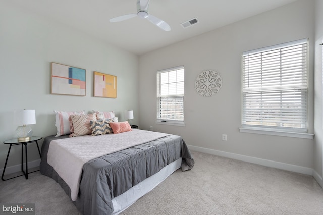 carpeted bedroom featuring baseboards, visible vents, and a ceiling fan