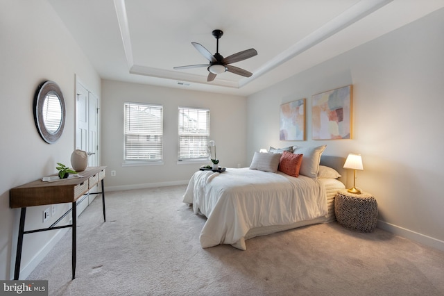 bedroom featuring ceiling fan, carpet floors, visible vents, baseboards, and a raised ceiling