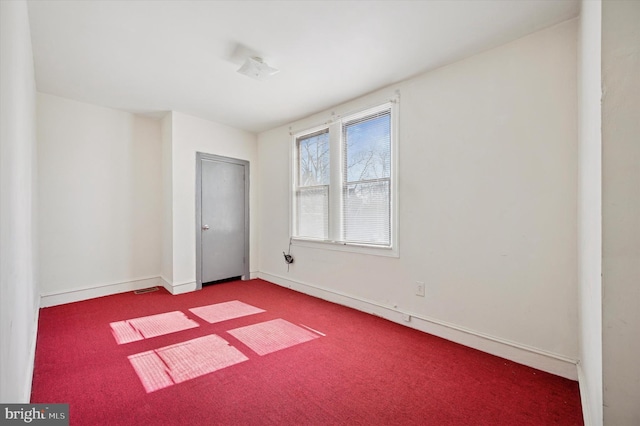 carpeted empty room featuring visible vents and baseboards