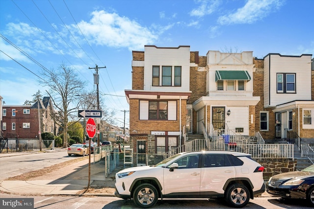 view of property featuring fence and brick siding