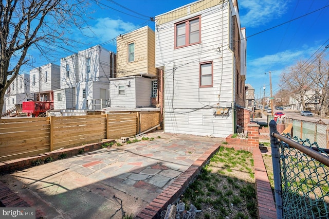 back of house with a patio and fence