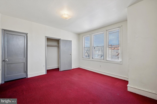 unfurnished bedroom featuring a closet, baseboards, and carpet floors