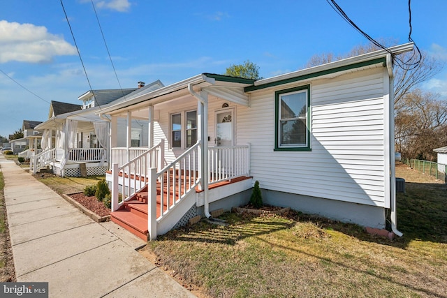 bungalow-style home featuring a front lawn and covered porch