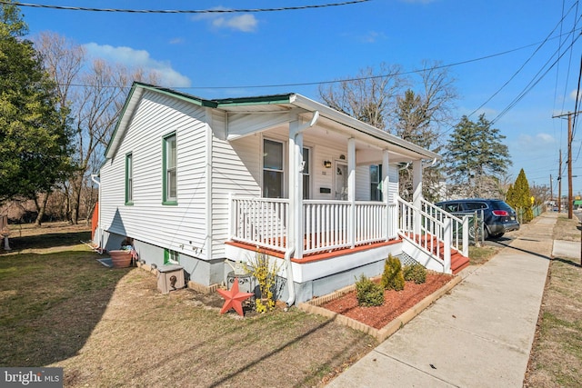 bungalow-style home with a porch and a front yard