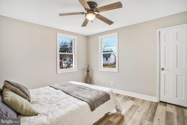 bedroom featuring a ceiling fan, light wood-type flooring, and baseboards