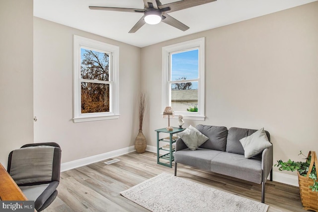 office space with visible vents, ceiling fan, light wood finished floors, and baseboards