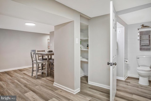 interior space featuring wood finished floors, toilet, and baseboards