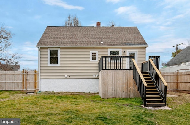 back of house featuring a chimney, a yard, stairs, fence, and a wooden deck