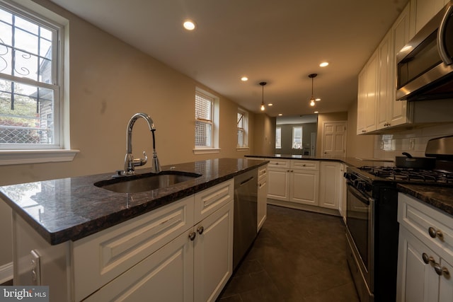 kitchen with stainless steel appliances, recessed lighting, white cabinetry, a sink, and a peninsula