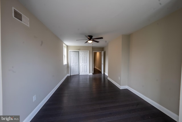 interior space with a ceiling fan, visible vents, baseboards, and wood finished floors