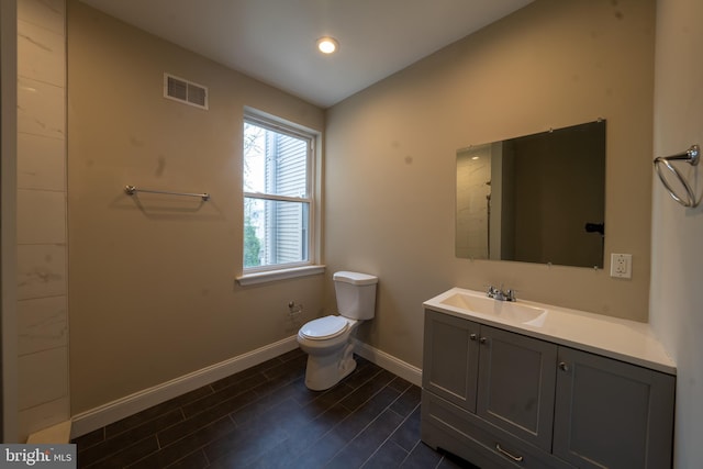 bathroom featuring visible vents, baseboards, toilet, wood tiled floor, and vanity