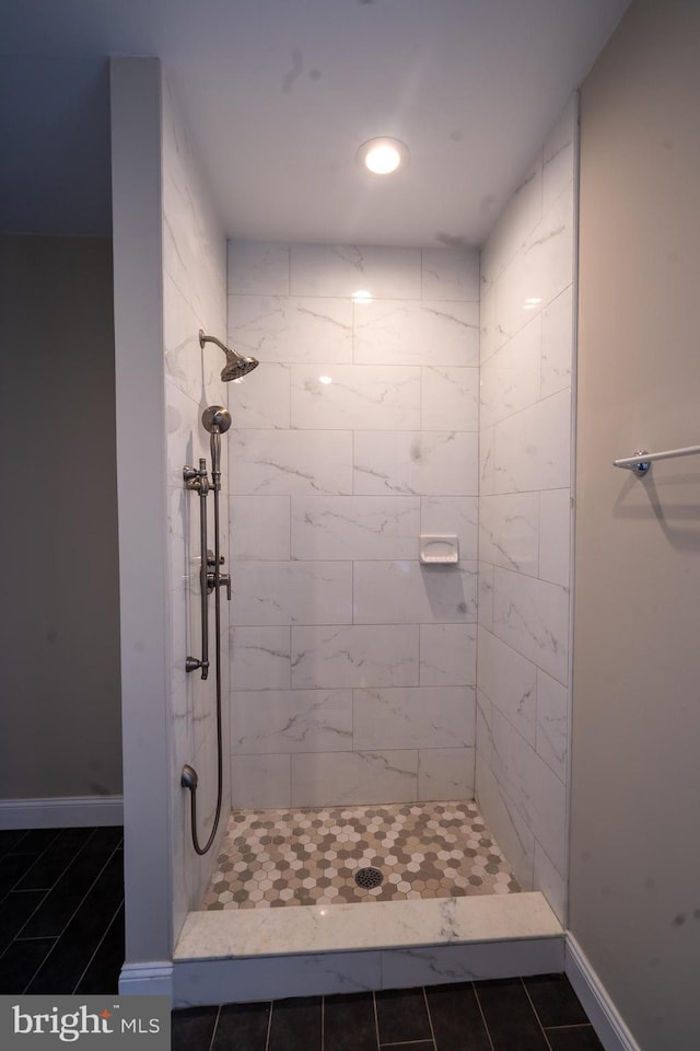 bathroom featuring a stall shower and baseboards