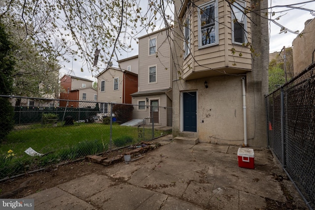 rear view of house with a patio area, a fenced backyard, a yard, and stucco siding